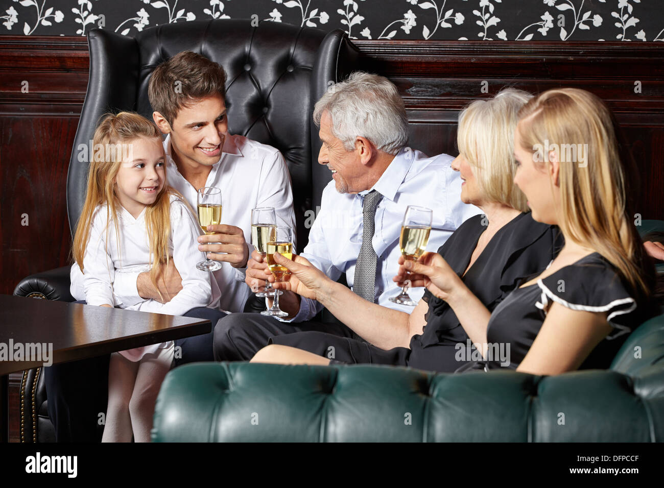 Famille heureuse à réception de mariage de boire un verre de vin mousseux Banque D'Images