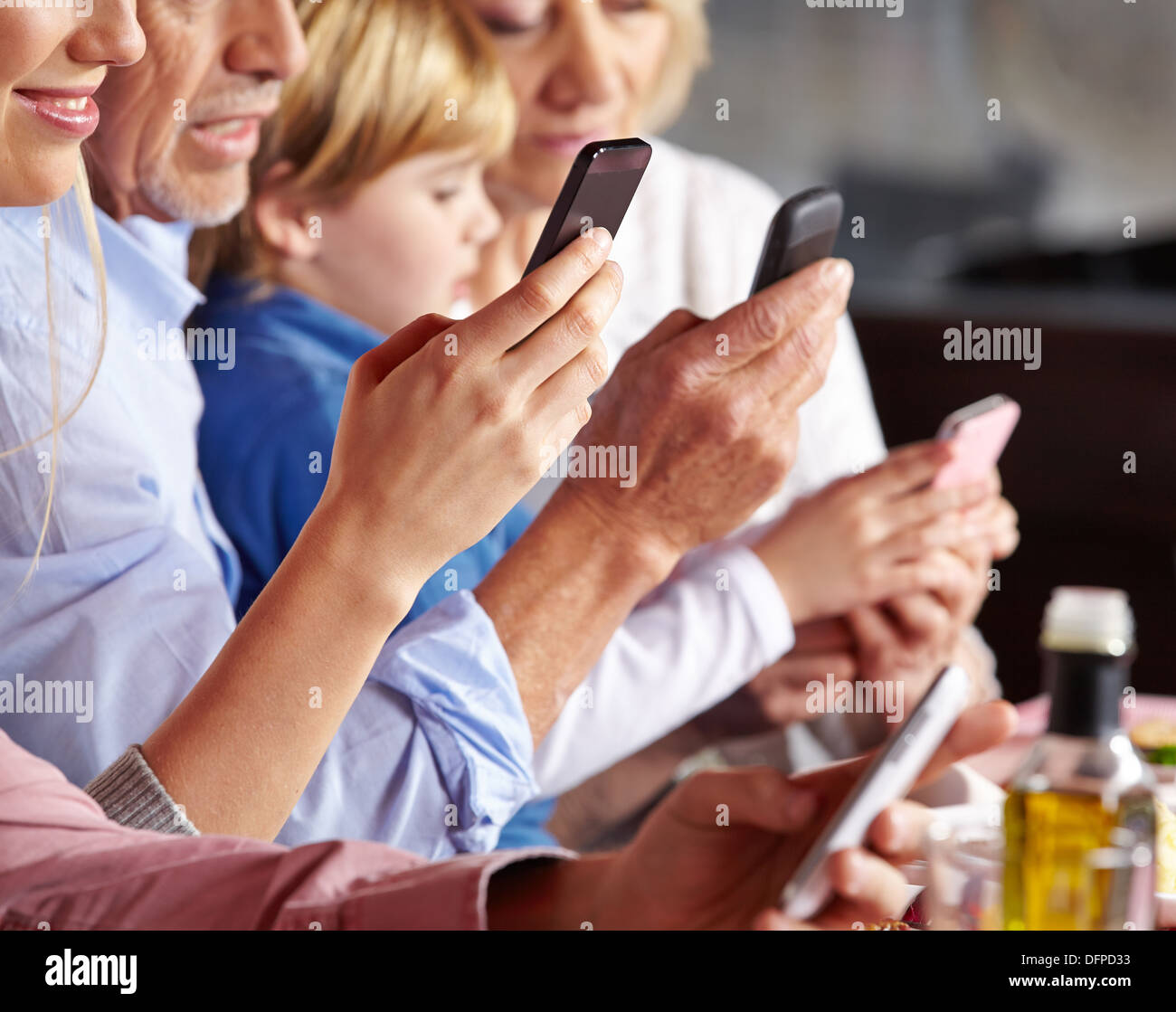 De nombreuses personnes contrôler leurs smartphones à la table de dîner Banque D'Images
