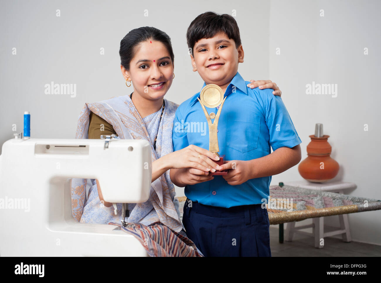 Portrait d'une femme avec son fils tenant un trophée et gagnante smiling Banque D'Images