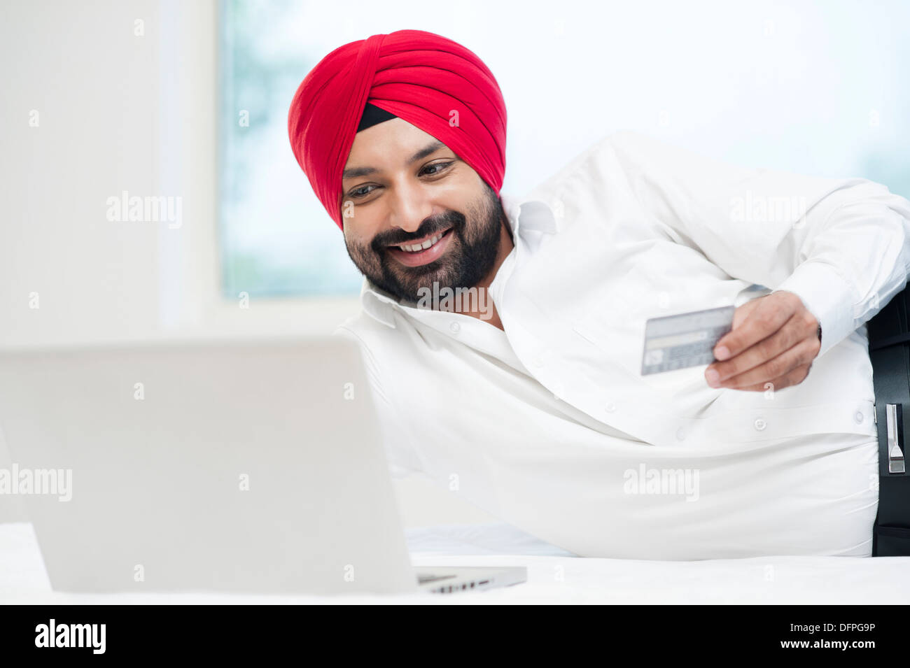 Homme Sikh faisant des achats en ligne avec une carte de crédit Banque D'Images