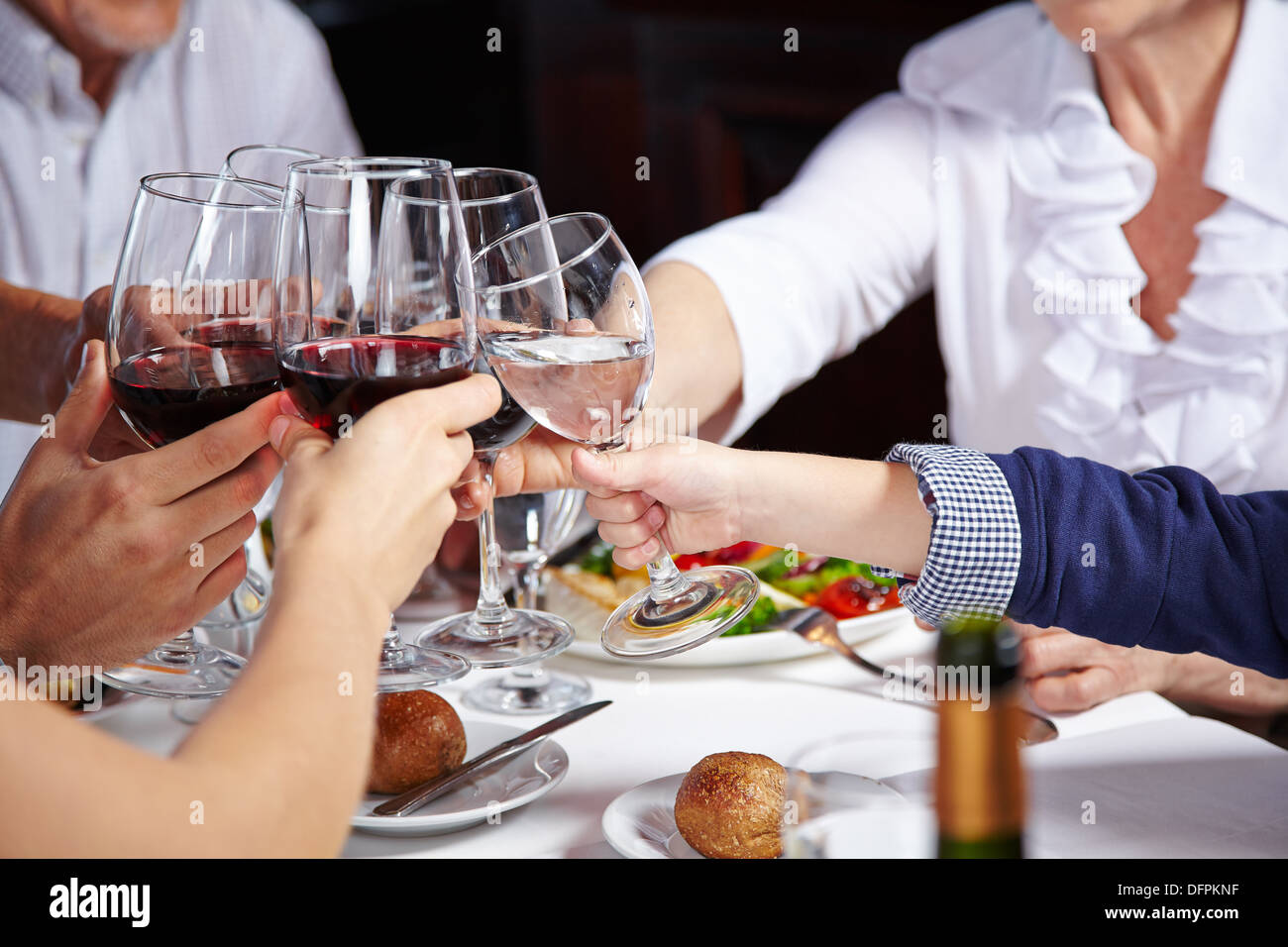 Friends toasting avec verres de vin rouge dans un restaurant Banque D'Images