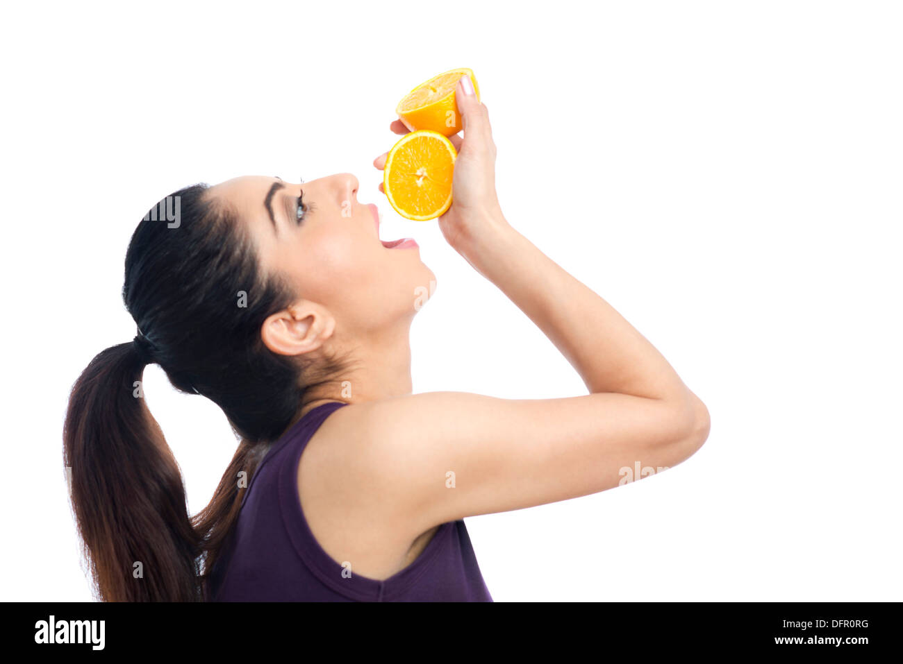 Femme boire du jus d'une orange Banque D'Images