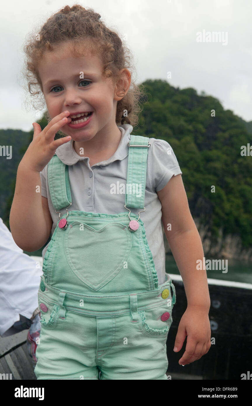 Fille mignonne avec des cheveux bouclés à bord d'un bateau de croisière dans la baie d'Halong, Vietnam Banque D'Images