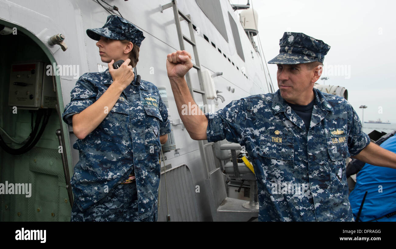 Le littoral lutte contre le USS Freedom (LCS 1) commandant, le cmdr. Pat Thien, les signaux à l'officier de pont pendant la manœuvre du navire dans la base navale de Changi, à Singapour. La liberté est à Singapour dans le cadre d'un déploiement outre-mer au sud-est Banque D'Images