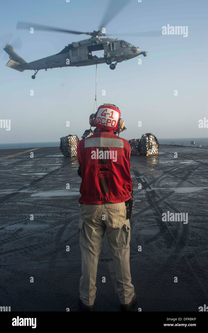 Le Ordnanceman Aviation Ronald Lee regarde un hélicoptère Seahawk MH-60 affecté à l'hélicoptère de chiens poussiéreux de l'Escadron de Combat de mer (HSC) 7 places fret sur le pont d'envol du porte-avions USS Harry S. Truman (CVN 75). Harry S. Truman Banque D'Images