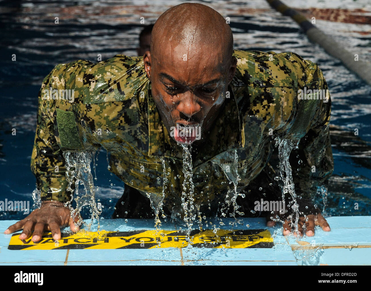 L'Hôpital de la marine de 2e classe Corpsman Rolando Brooks lui-même pousse hors de la piscine lors d'une course relais de nager. Les concurrents ont nagé une l Banque D'Images