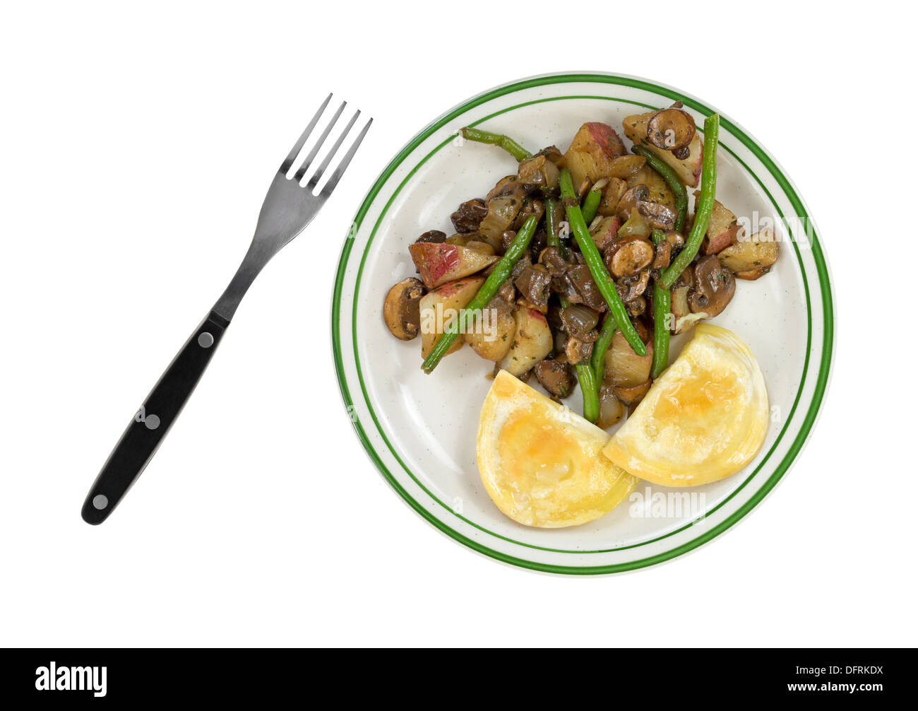 Vue de dessus d'un repas des pierogies avec haricots verts, champignons, oignons et pommes de terre rouge sur une assiette avec une fourchette sur le côté. Banque D'Images