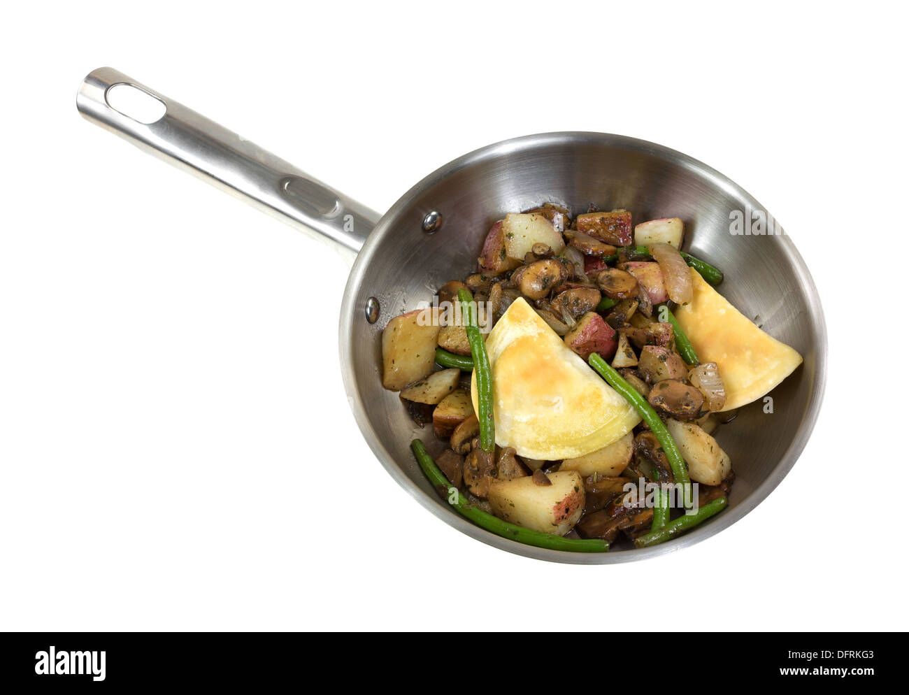Pierogies avec des pommes de terre et les haricots verts la cuisson dans une poêle en acier inoxydable sur un fond blanc Banque D'Images