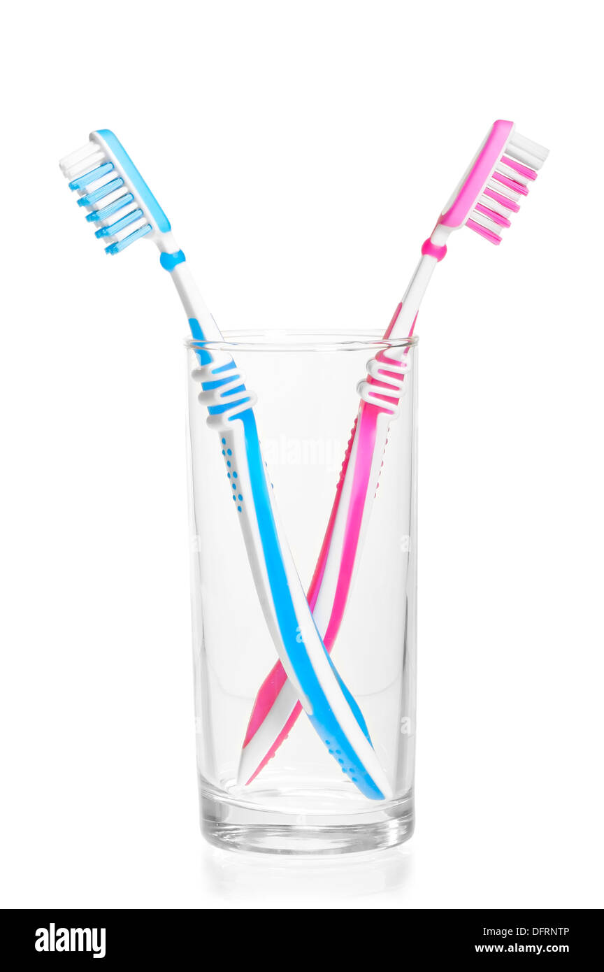 Brosses à dents se disputa dans un verre sur un fond blanc Banque D'Images