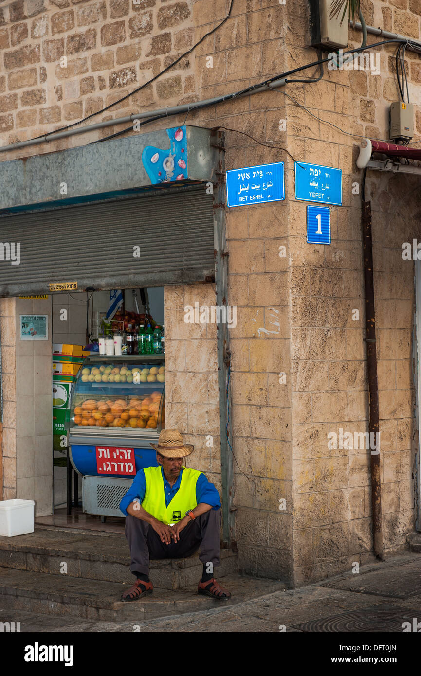 Un travailleur de l'assainissement est de prendre une pause du travail dans la rue, dans la vieille ville de Jaffa / Yafo, Israël Banque D'Images