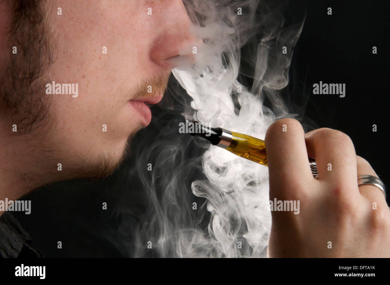 Homme qui fume une cigarette électronique vapeur et l expiration Photo  Stock