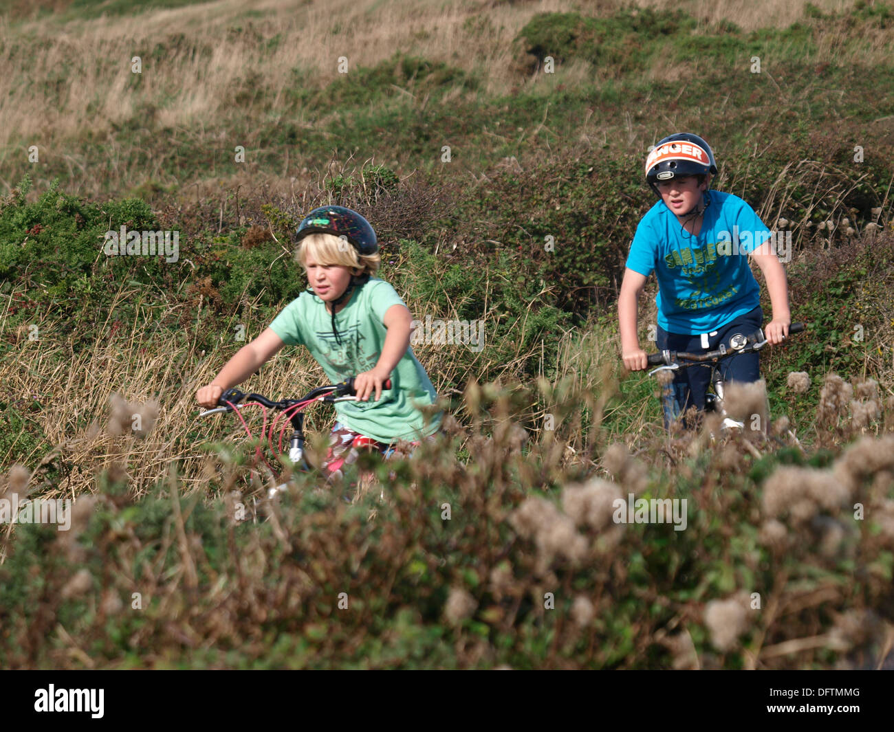 Deux garçons faire du vélo le long de sentiers de campagne, Cornwall, UK Banque D'Images