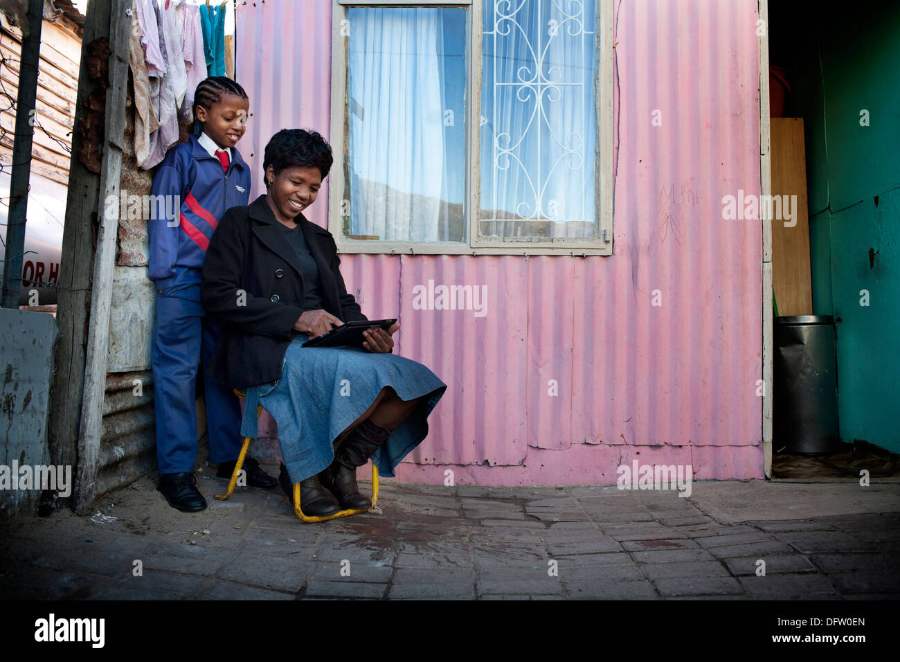 Azasakhe et sa mère Alphonsina examine l'internet sur l'iPad à l'extérieur de leur maison de Masiphumalele, Cape Town, Afrique du Sud. Banque D'Images