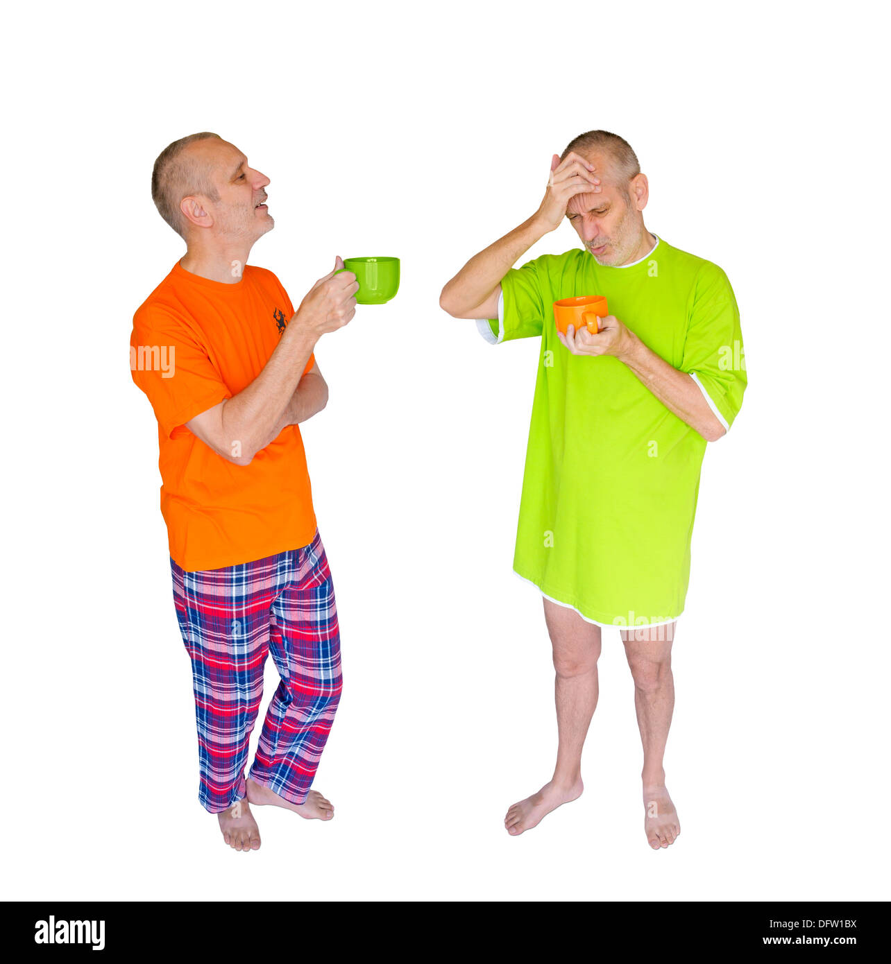 Un couple d'hommes double de boire du café après le réveil. L'un en vert tient une tasse orange, l'autre avec un T-shirt orange détient un bol vert Banque D'Images