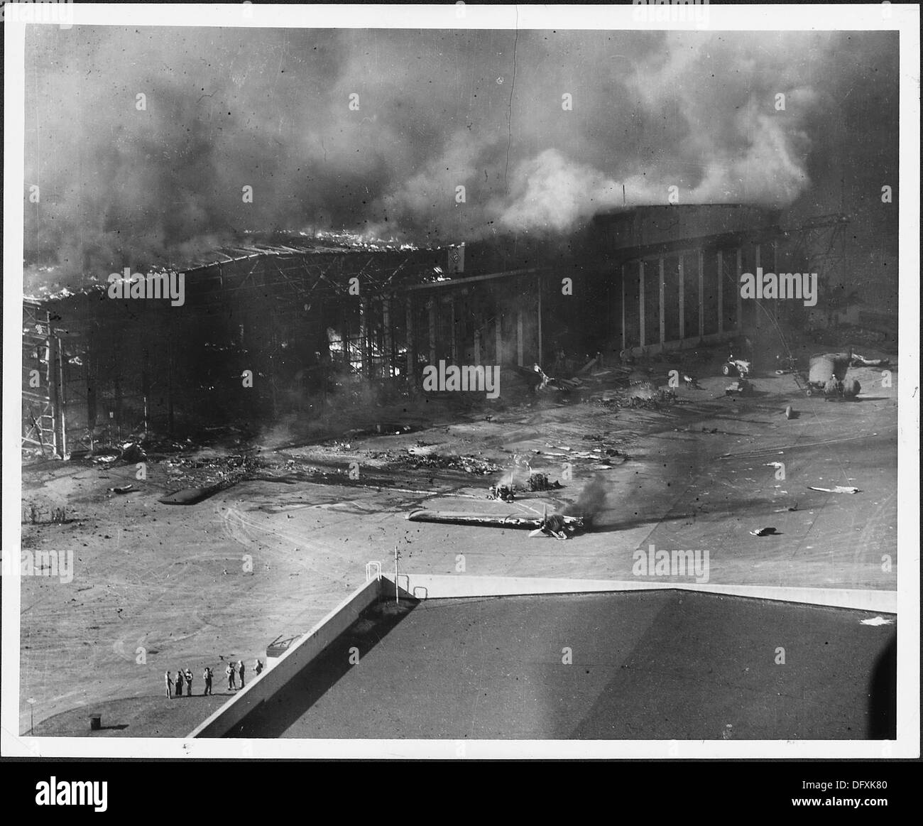 Une photographie montrant la dévastation à Pearl Harbor, où des hangars et des avions ont été endommagés et incendiés par des bombes japonaises lors de l'attaque du 7 décembre 1941. Cette image capture la destruction causée par le raid de bombardement. Banque D'Images