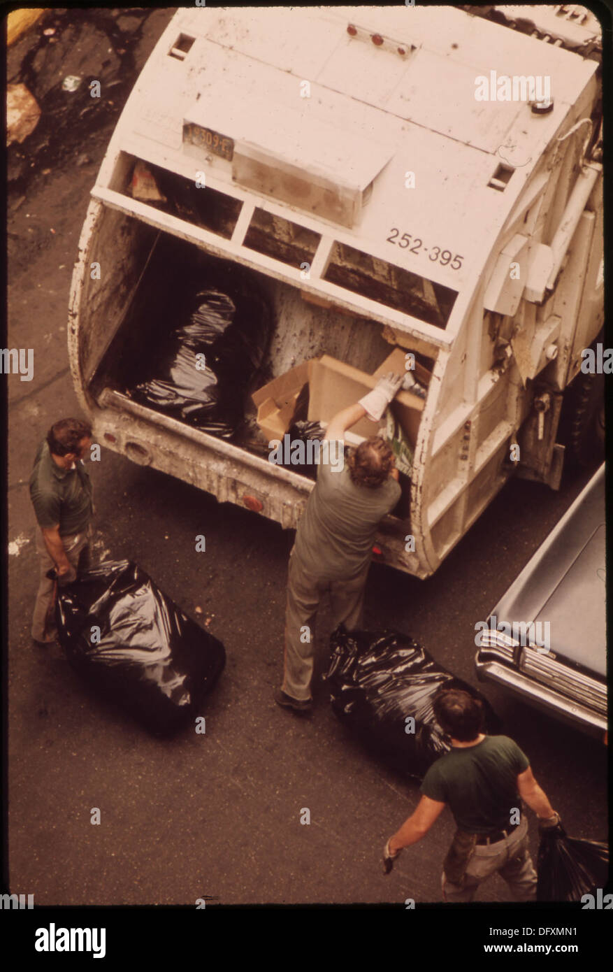 On voit des travailleurs de l'assainissement ramasser des ordures sur la 172e rue à Manhattan. L’image capture un service urbain essentiel assurant la propreté de la ville. Banque D'Images