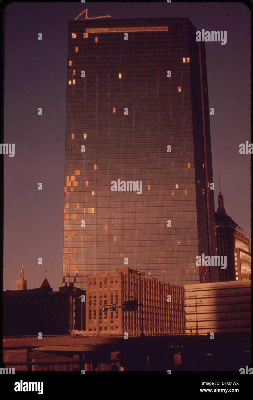Cette image capture le John Hancock Building, conçu à l'origine comme un gratte-ciel moderne avec des fenêtres lumineuses. Cependant, il est devenu un symbole de déclin dû aux fenêtres cassées, reflétant un changement dans son état perçu au fil du temps. Banque D'Images