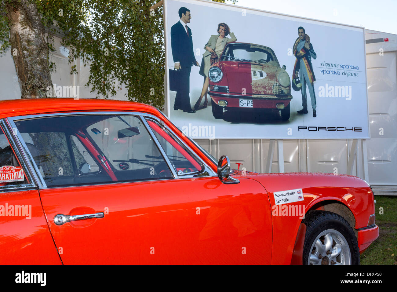 Porsche 911 s'affichent. Howard Warren et Iain Tullie's voiture en face d'un bandeau publicitaire Porsche. 2013 Goodwood Revival, Sussex Banque D'Images