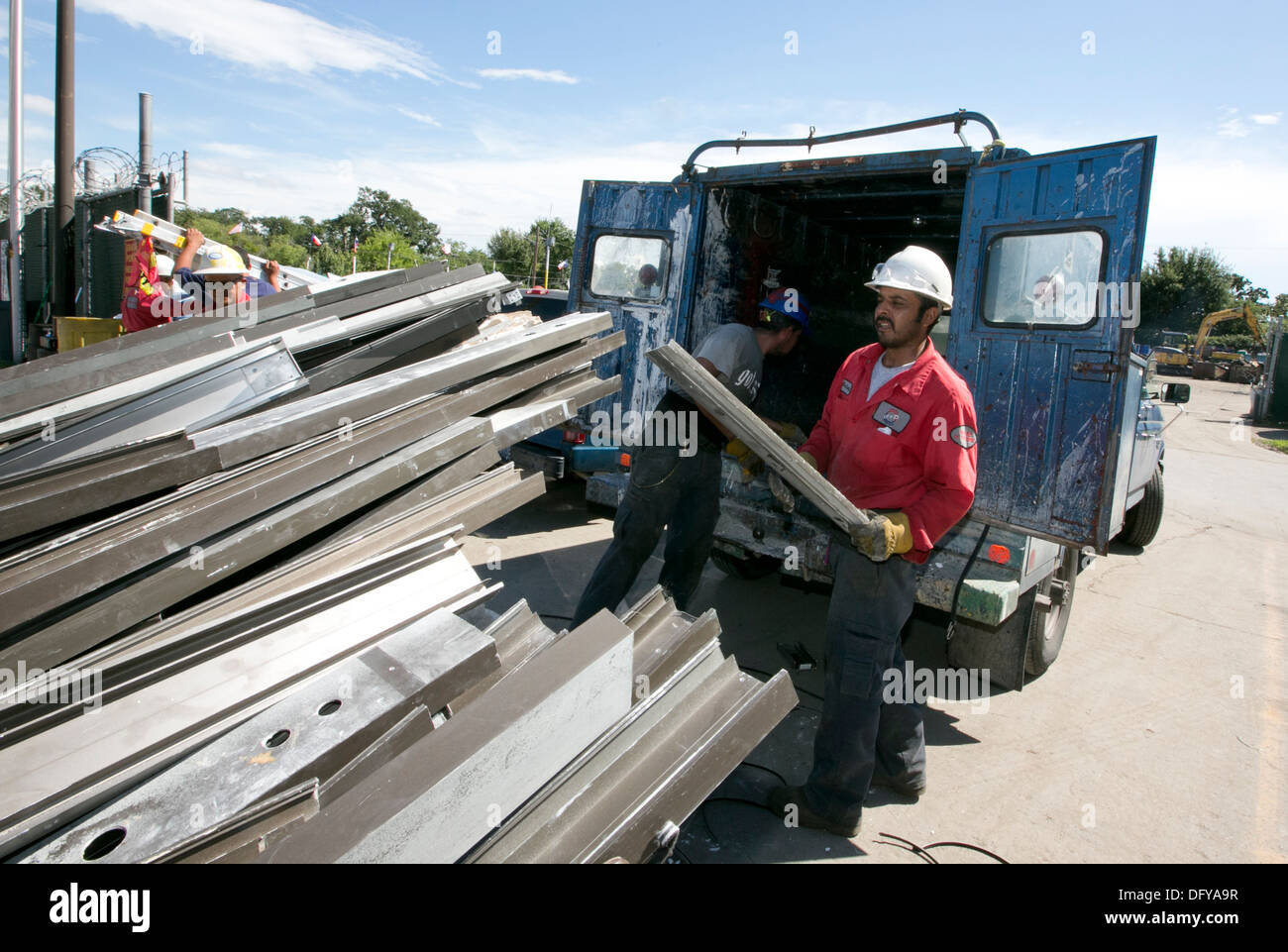 Les travailleurs hispaniques organiser poutres métalliques pour le recyclage à l'entreprise de ferraille au Texas Banque D'Images