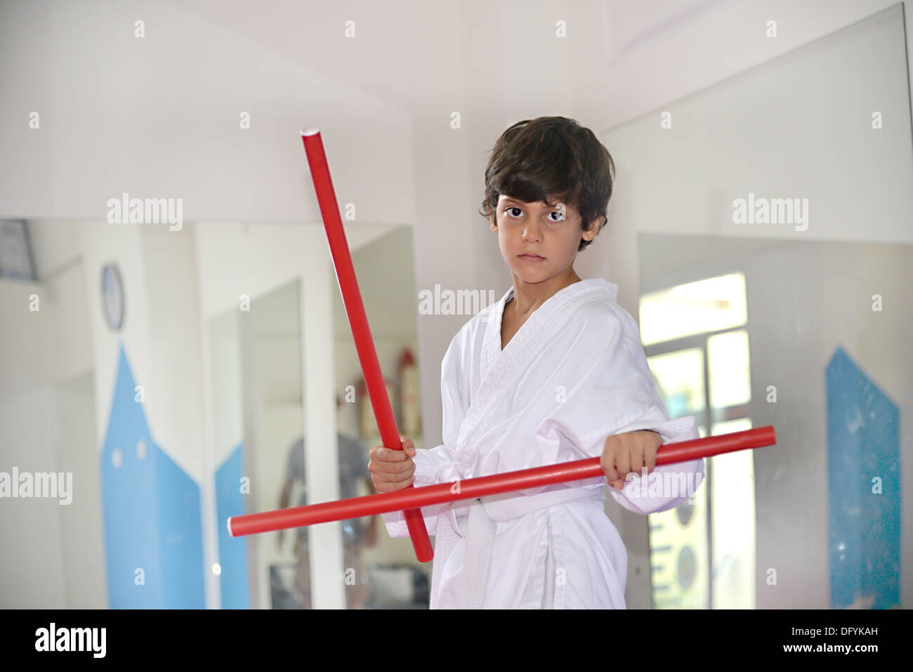 Arts martiaux garçon tenant deux bâtons rouge appelé ka-li - lutte contre le bois Banque D'Images