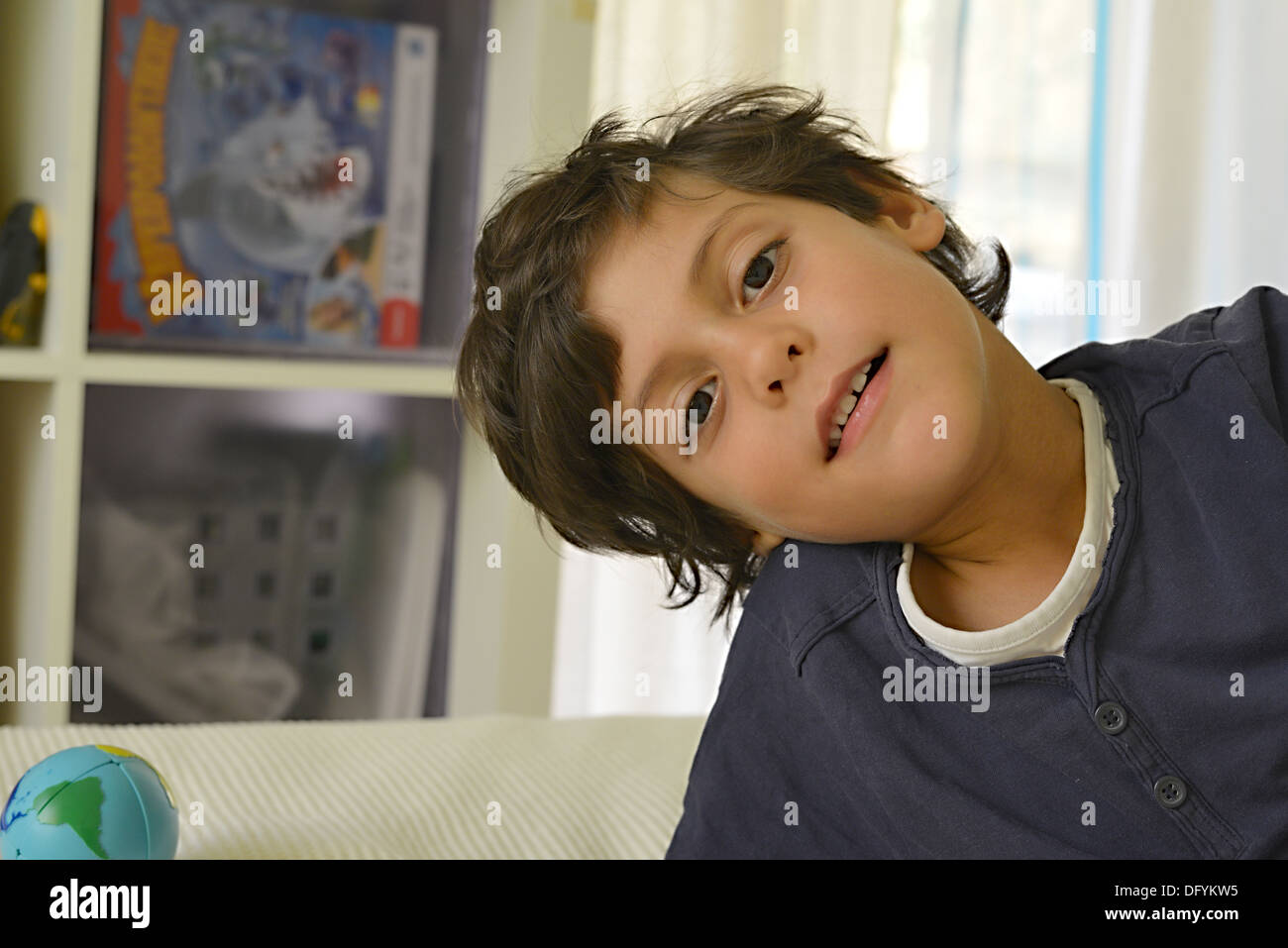 Boy smiling avec terre près de lui en miniature Banque D'Images