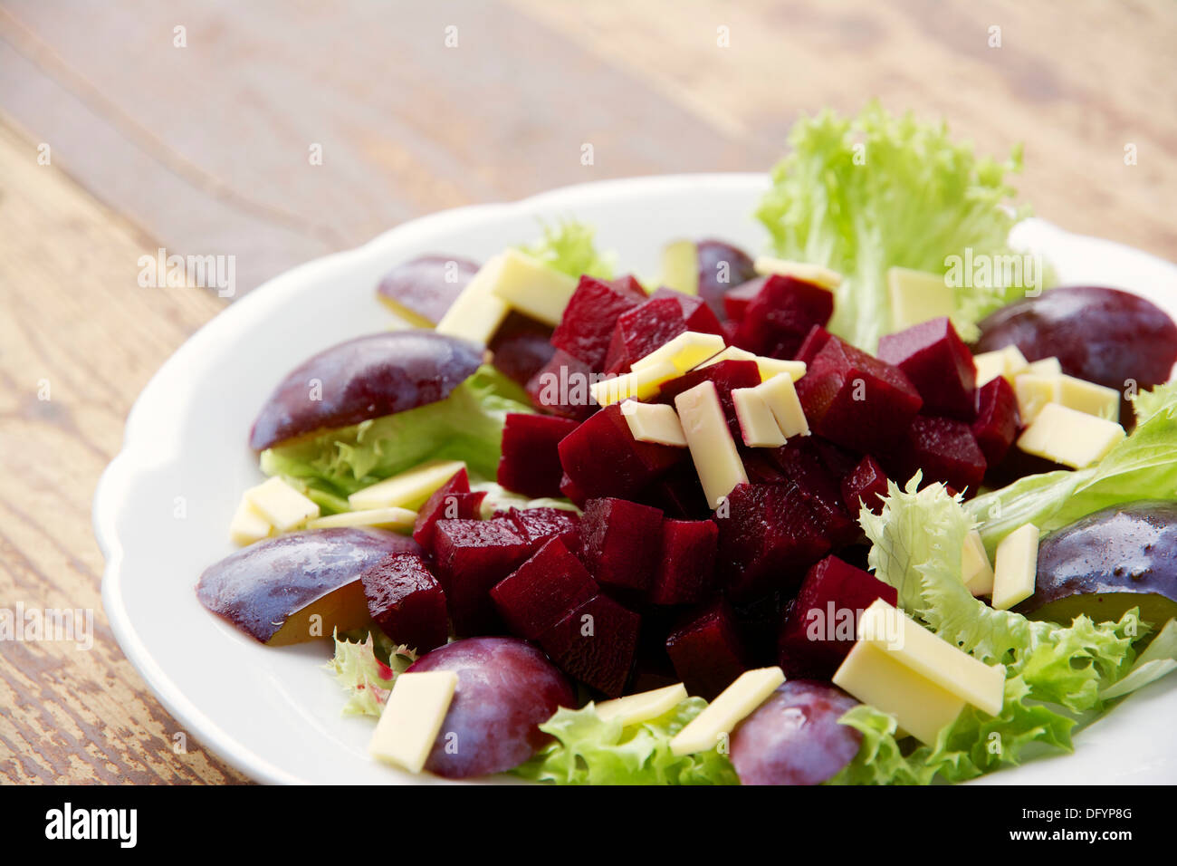 Betteraves rouges, prunes, Fromage Végétalien sur lit de laitue Lollo Bianco. Vinaigrette de vinaigre balsamique avec sirop de cassis. Banque D'Images