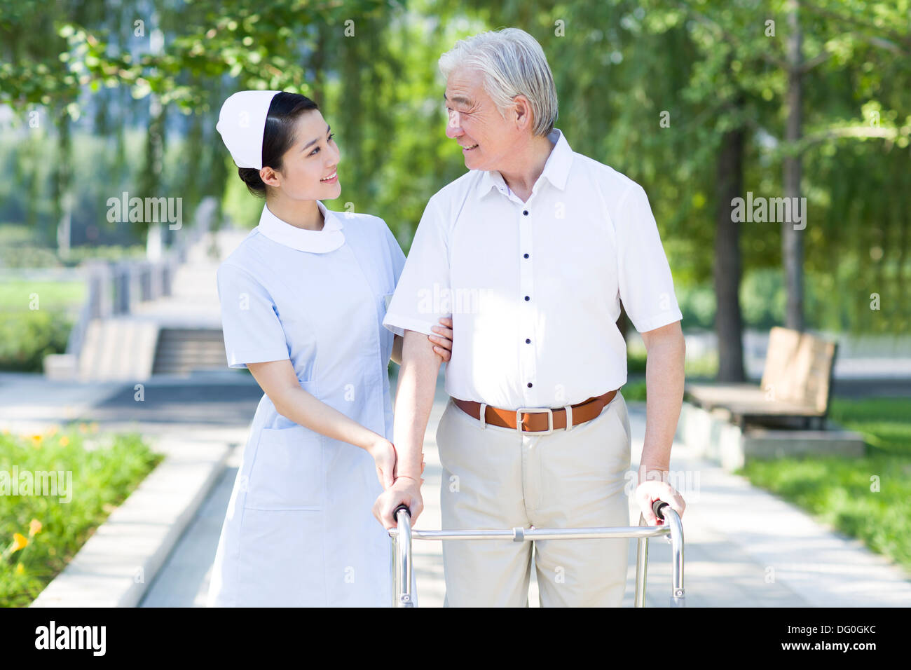Man Walking avec déambulateur sous l'assistance de l'infirmière Banque D'Images