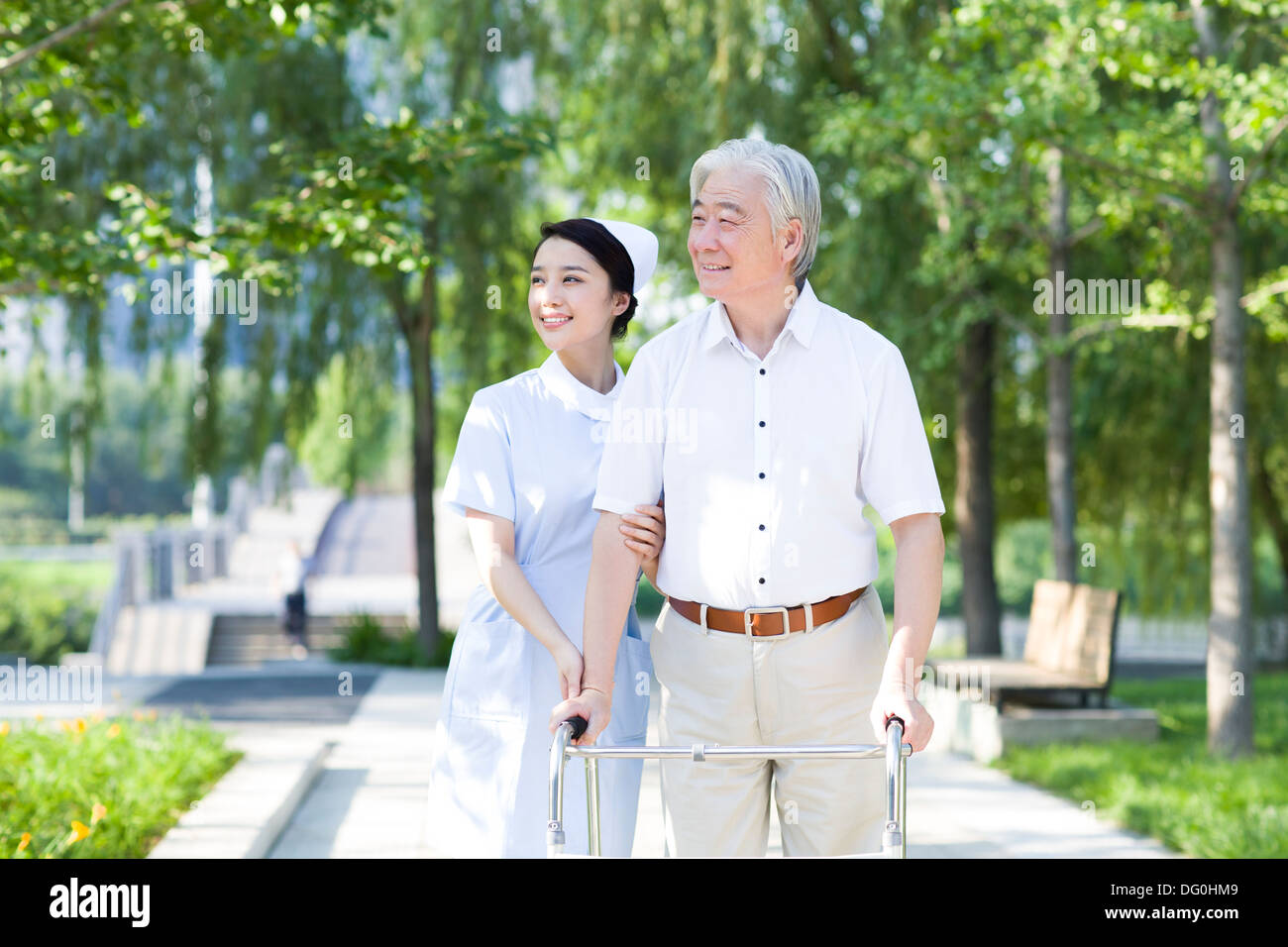 Man Walking avec déambulateur sous l'assistance de l'infirmière Banque D'Images