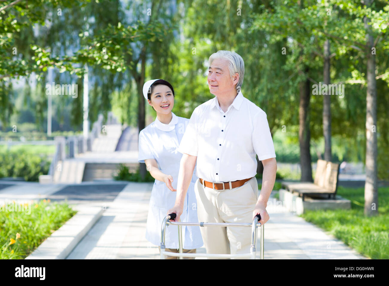 Man Walking avec déambulateur sous l'assistance de l'infirmière Banque D'Images