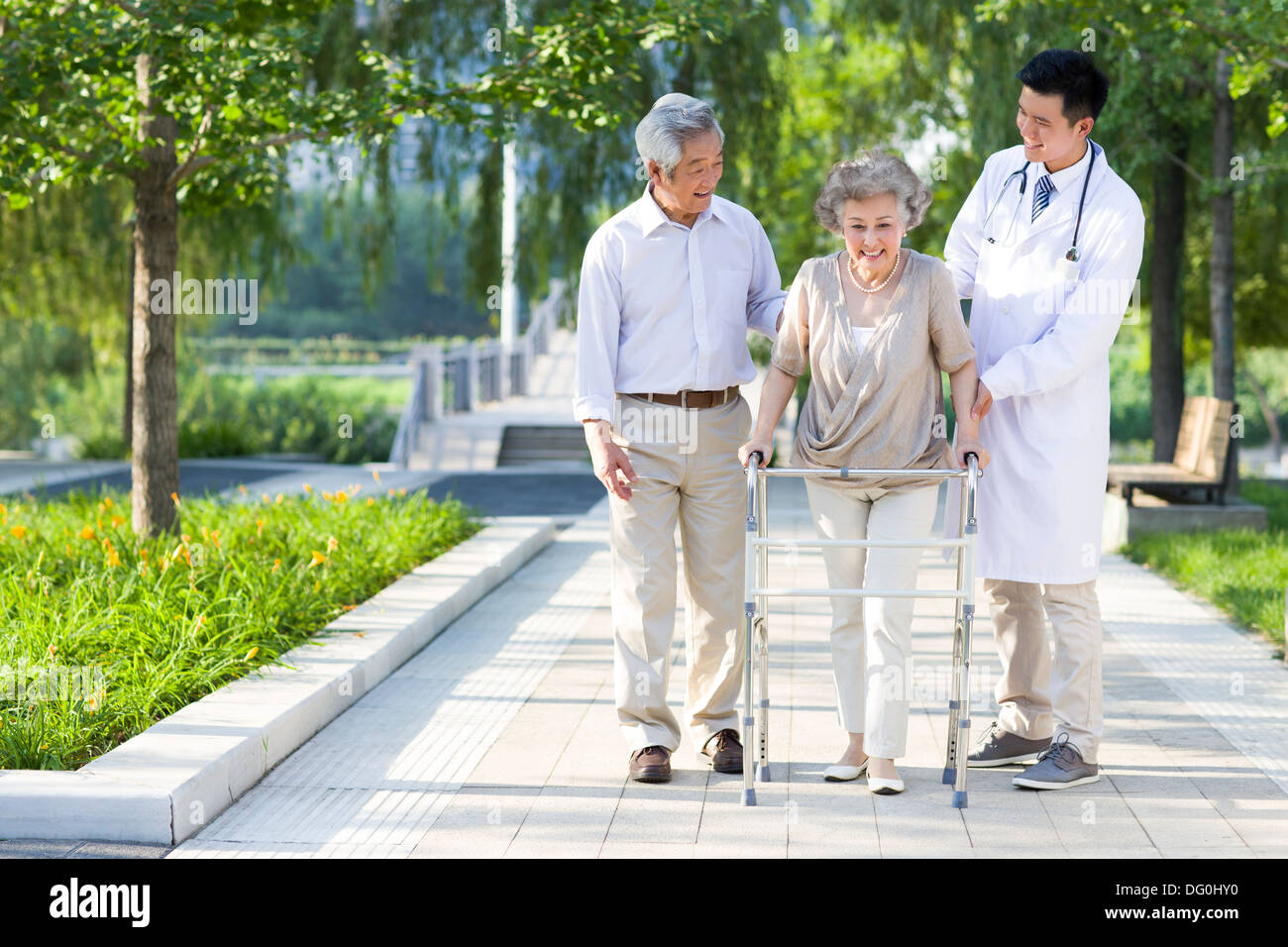 Senior woman walking with walking châssis sous l'assistance du mari et médecin Banque D'Images