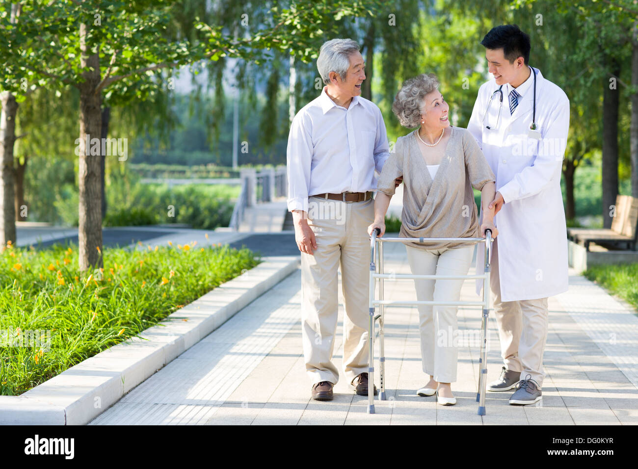Senior woman walking with walking châssis sous l'assistance du mari et médecin Banque D'Images