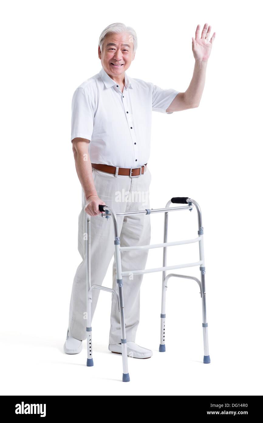 Smiling senior man with walker waving Banque D'Images