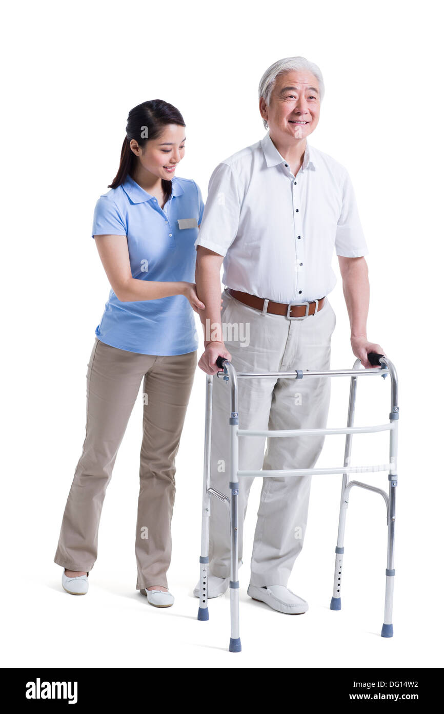 Infirmière auxiliaire féminine senior aidant avec déambulateur Banque D'Images