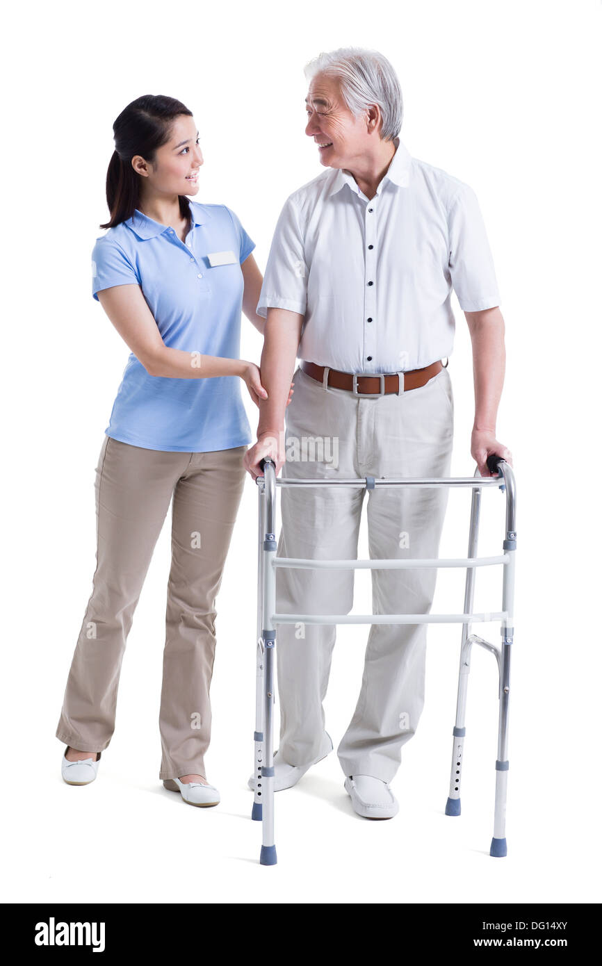 Infirmière auxiliaire féminine senior aidant avec déambulateur Banque D'Images