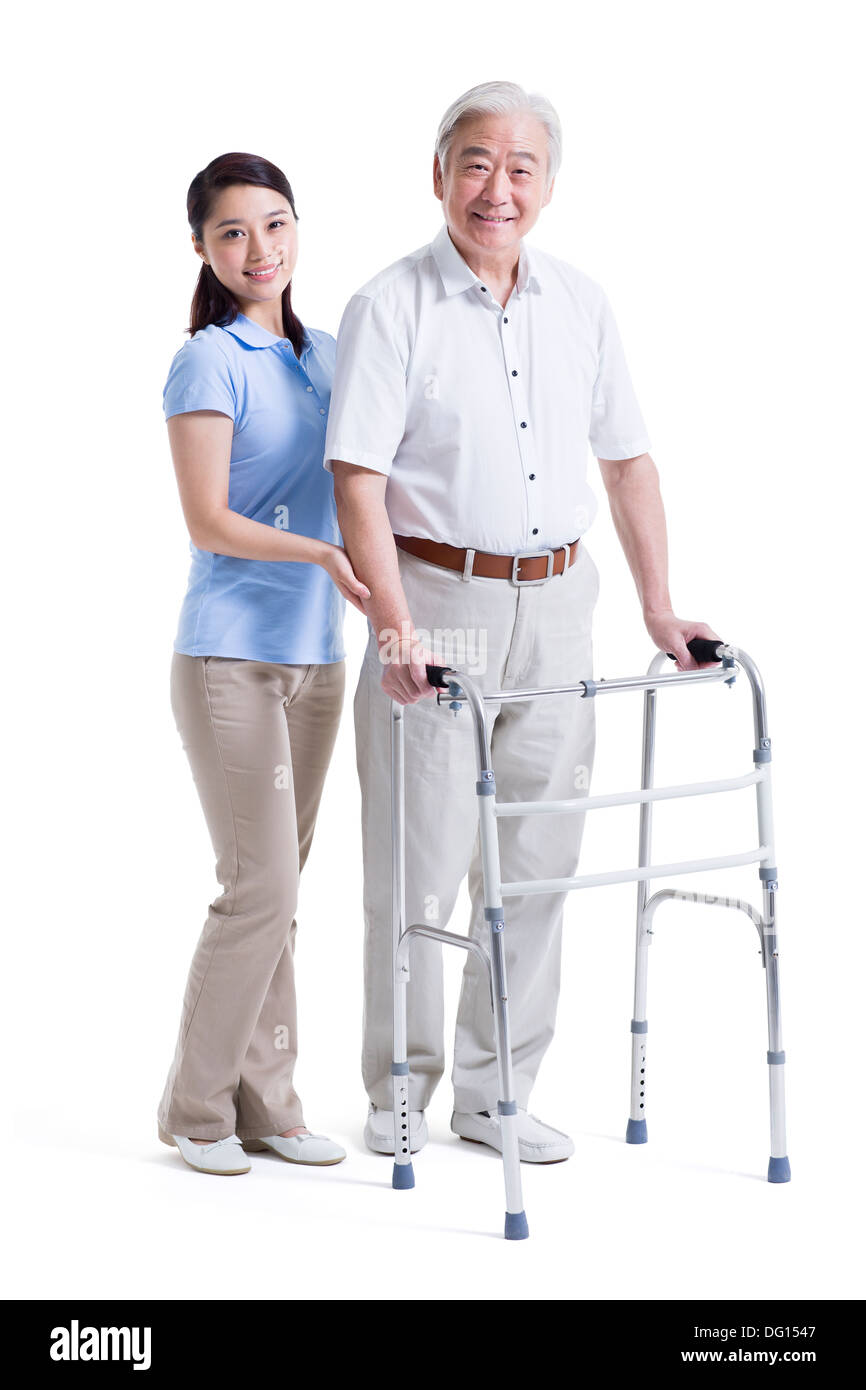 Infirmière auxiliaire féminine senior aidant avec déambulateur Banque D'Images