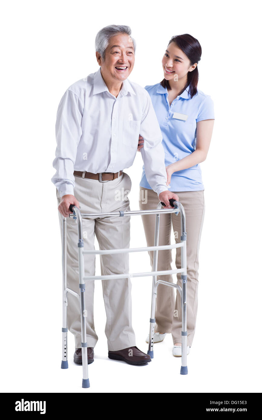 Infirmière auxiliaire féminine senior aidant avec déambulateur Banque D'Images