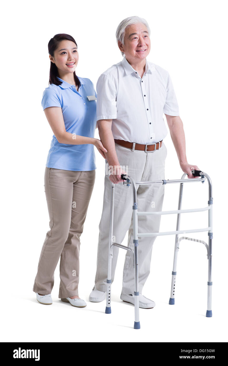 Infirmière auxiliaire féminine senior aidant avec déambulateur Banque D'Images