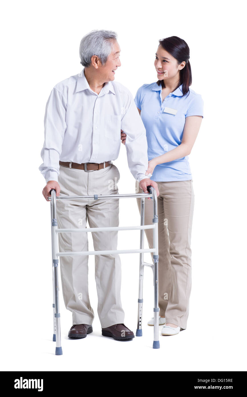 Infirmière auxiliaire féminine senior aidant avec déambulateur Banque D'Images