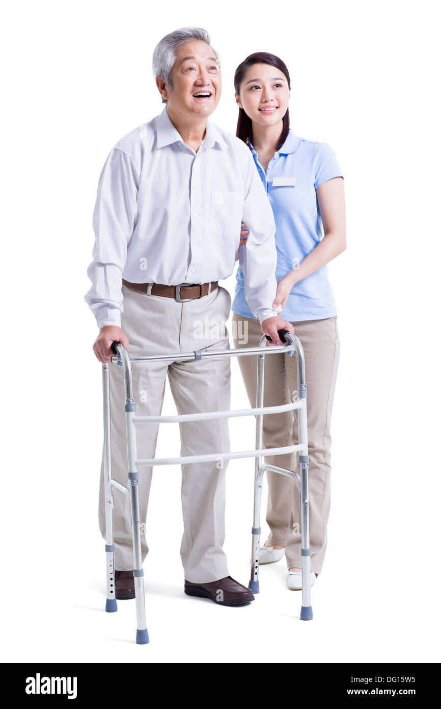 Infirmière auxiliaire féminine senior aidant avec déambulateur Banque D'Images