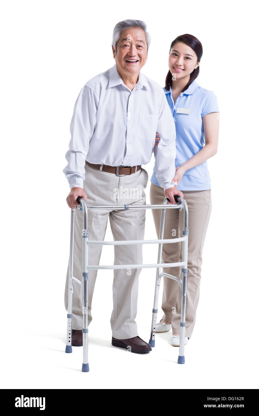 Infirmière auxiliaire féminine senior aidant avec déambulateur Banque D'Images