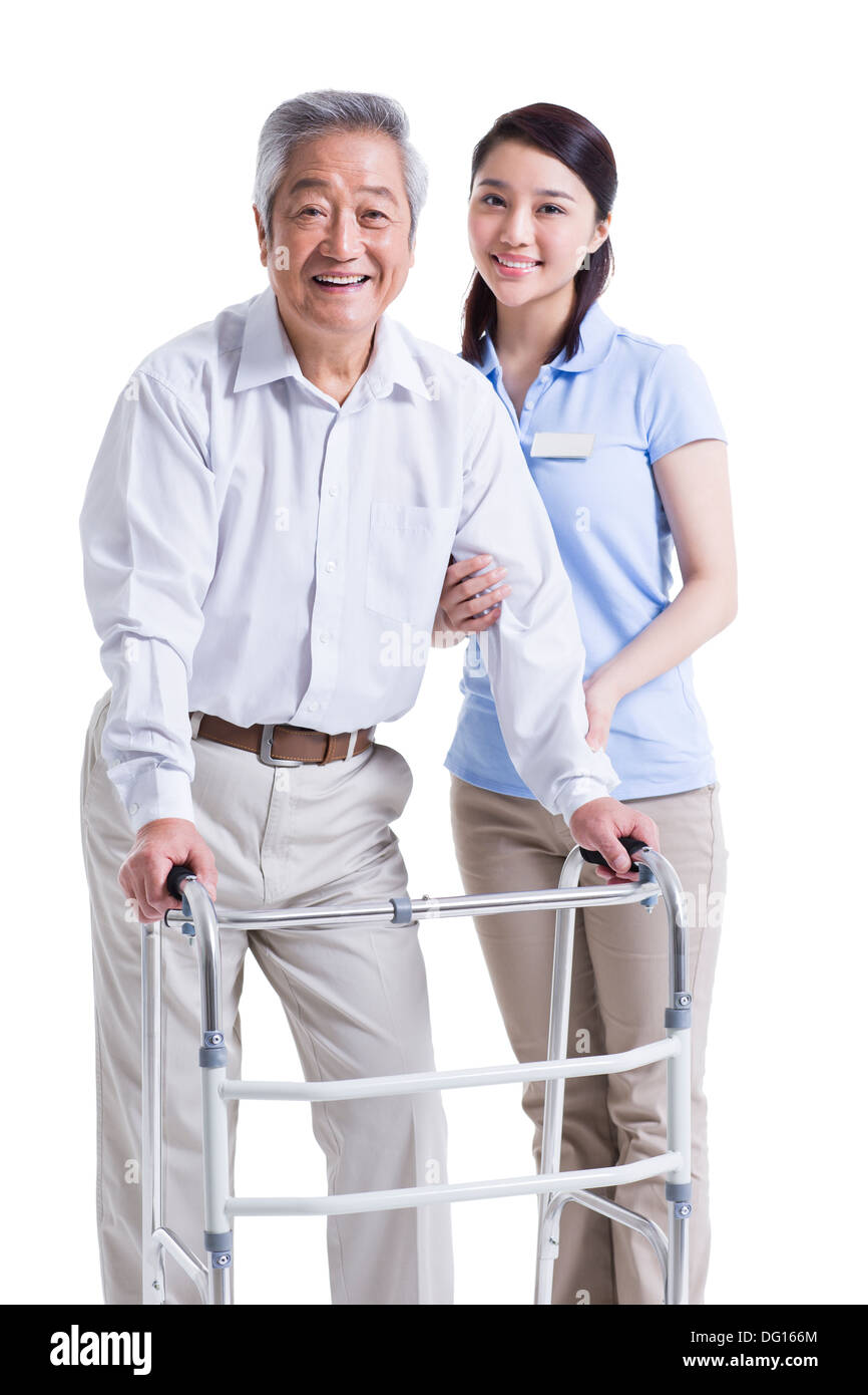 Infirmière auxiliaire féminine senior aidant avec déambulateur Banque D'Images