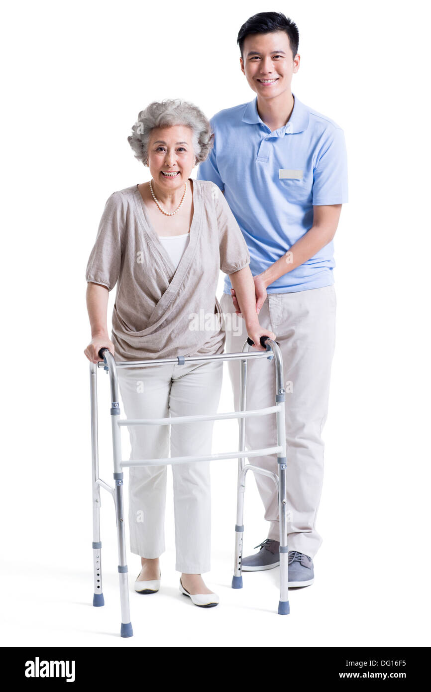 Assistant de soins infirmiers masculins aidant les femme avec déambulateur Banque D'Images