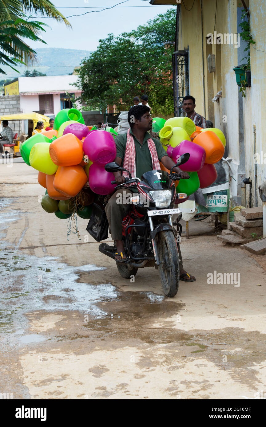 L'homme indien indien vente de plastique de l'eau transportant la casserole  de sa moto dans un village de l'Inde rurale. L'Andhra Pradesh, Inde Photo  Stock - Alamy