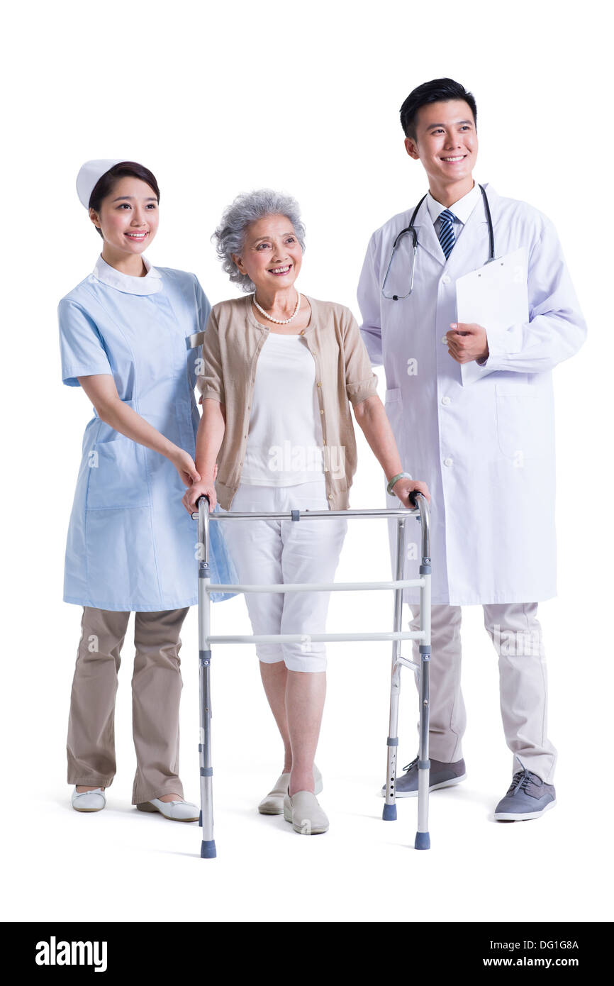 Médecin , infirmière et patient avec déambulateur Banque D'Images