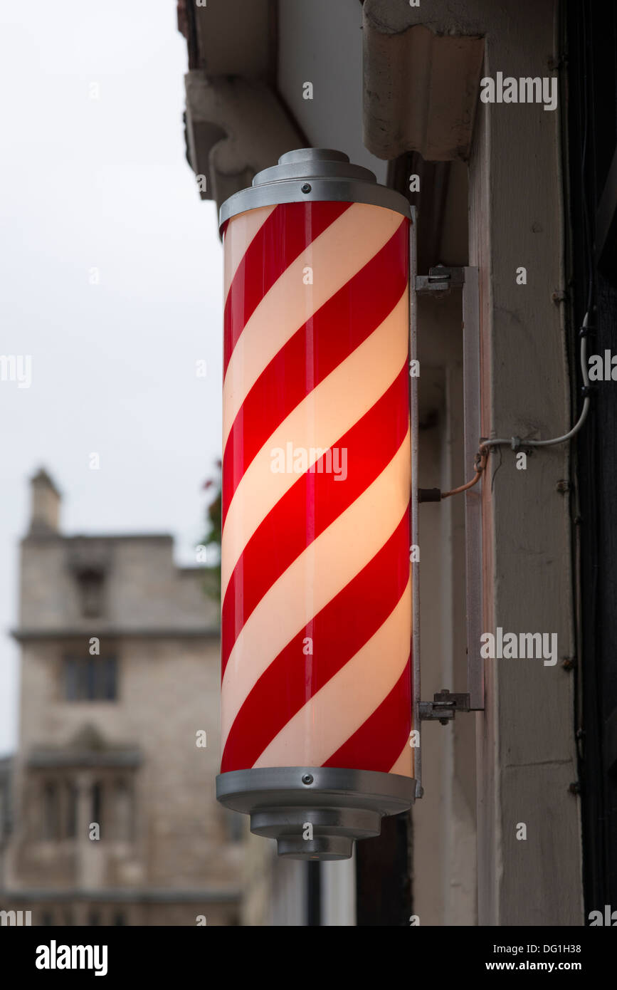 Un coiffeur à rayures rouges et blanches à l'extérieur pôle un magasin à Cambridge UK Banque D'Images