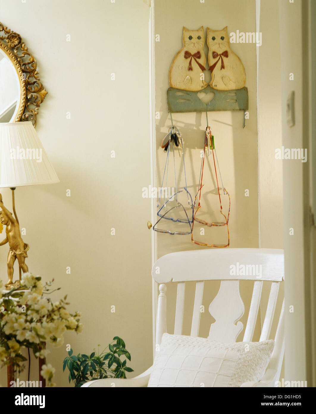 Président ci-dessous peint en blanc motif chat rack de stockage avec spectacles en chambre cottage Banque D'Images