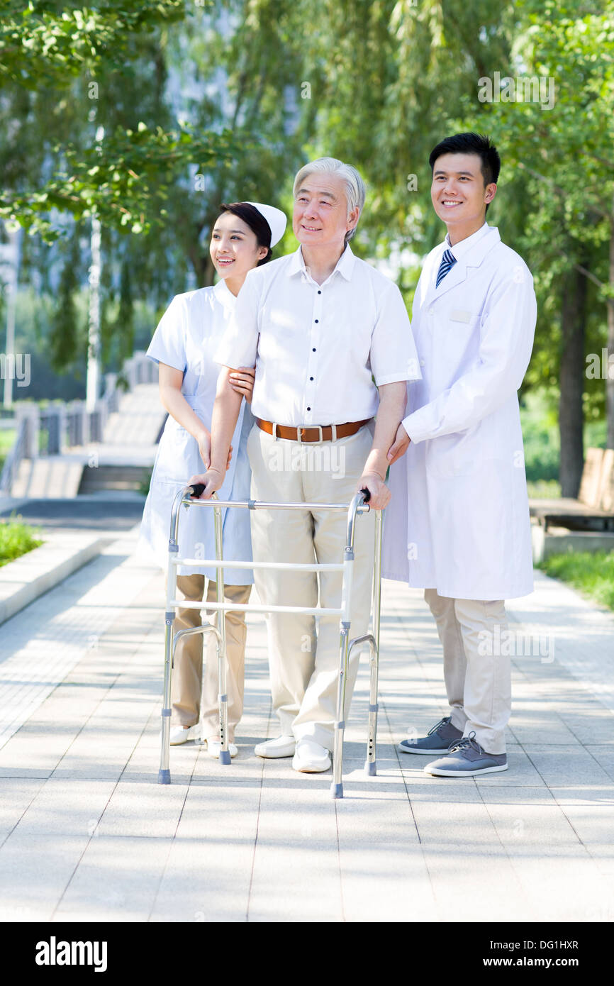 Man Walking avec déambulateur sous l'assistance de l'infirmière et médecin Banque D'Images