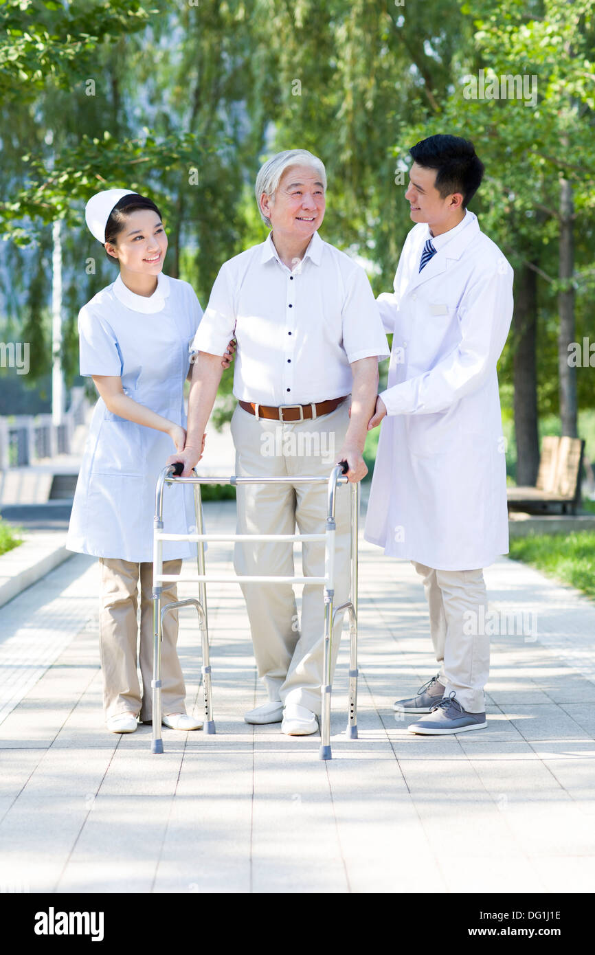 Man Walking avec déambulateur sous l'assistance de l'infirmière et médecin Banque D'Images