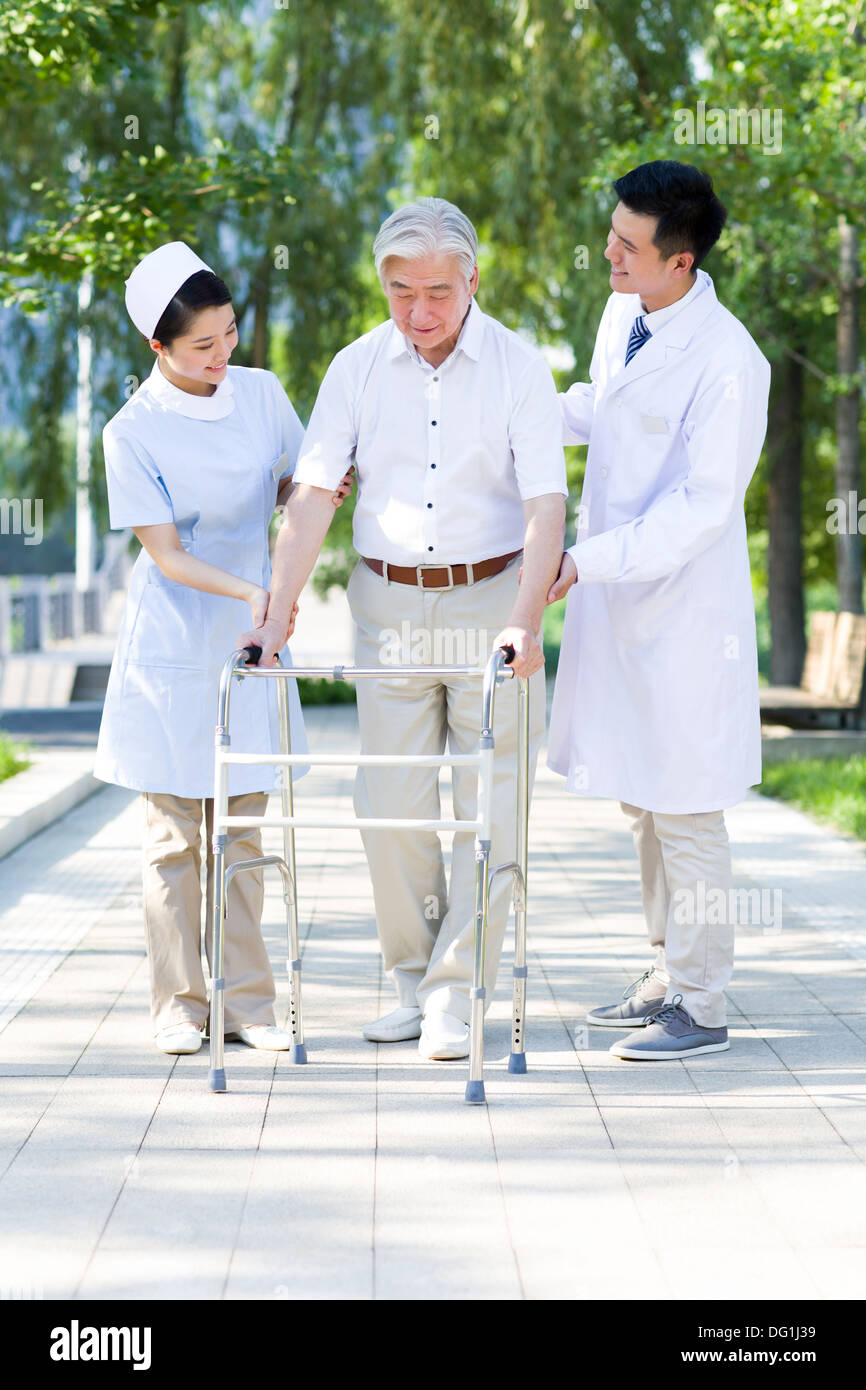 Man Walking avec déambulateur sous l'assistance de l'infirmière et médecin Banque D'Images