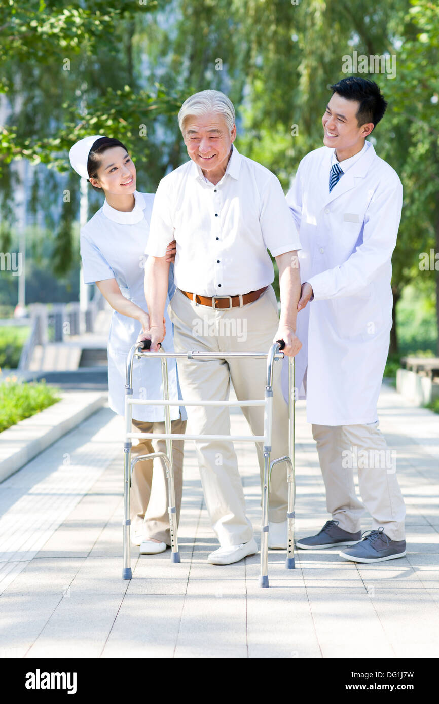 Man Walking avec déambulateur sous l'assistance de l'infirmière et médecin Banque D'Images